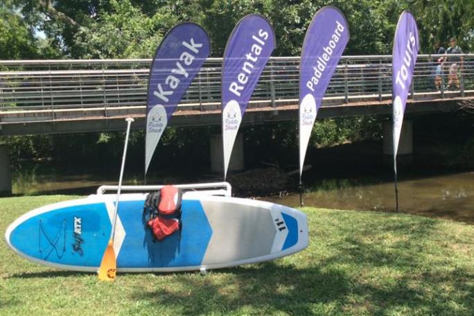 a row of lawn chairs sitting on top of a grass covered field