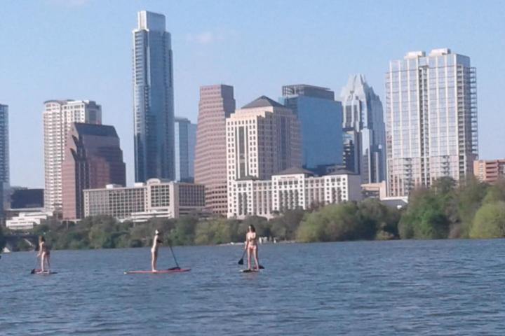people stand up paddle boarding on lady bird lake in austin texas