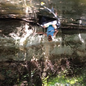 kayker in water near stone bluff