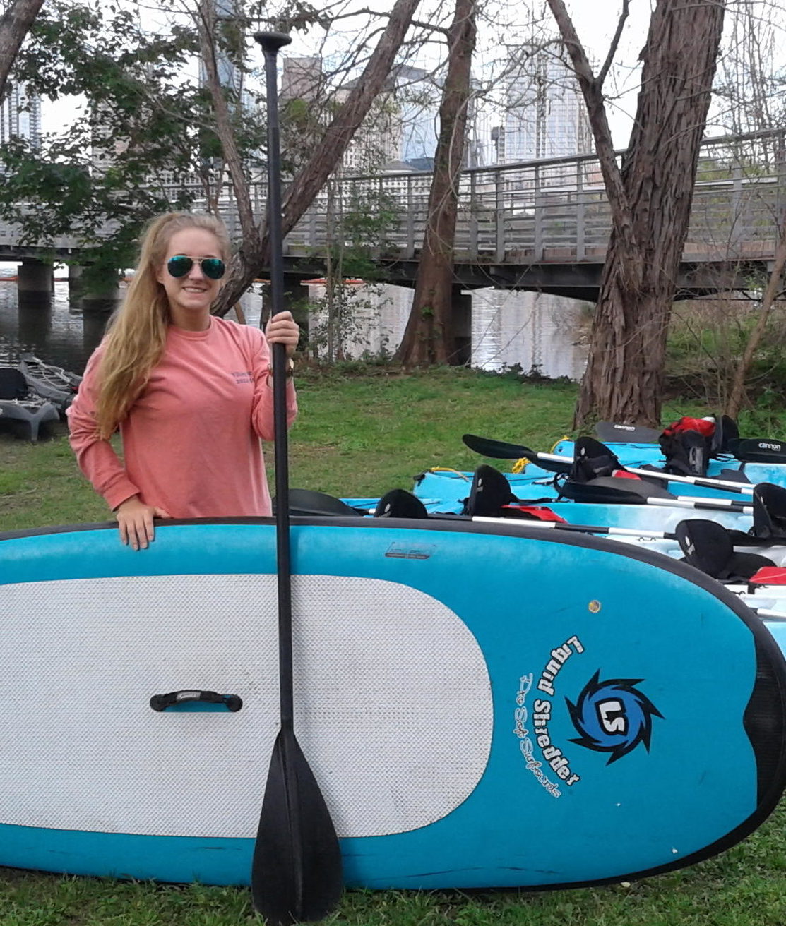 woman standing with stand up paddle board rental